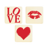 set of three square white chocolate plaques featuring red printed designs: the word 'LOVE', a pair of kissing lips, and a brush-stroke heart.
